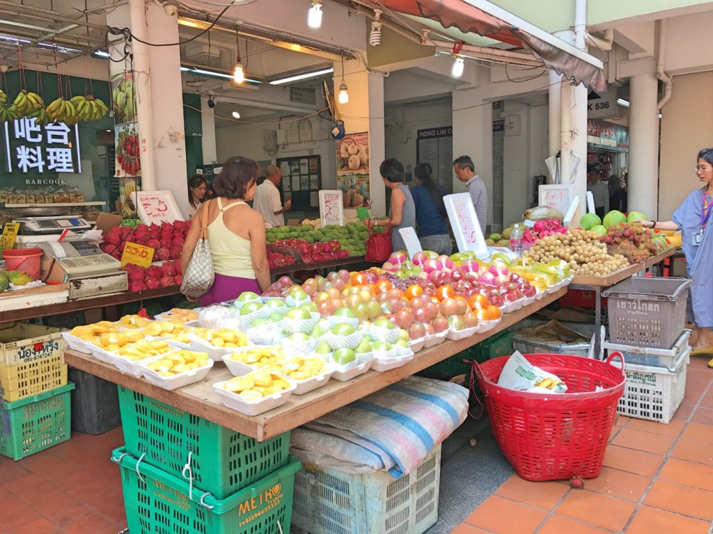 Meyve tazgahından, insanların alışveriş yaptığı bir görüntü.