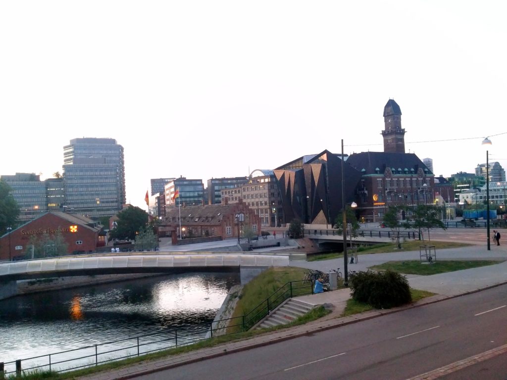 Malmö gezi rehberi yazısı için şehrinn uzaktan çekilmiş binaların, köprünün ve nehrin yer aldığı bir görüntü.