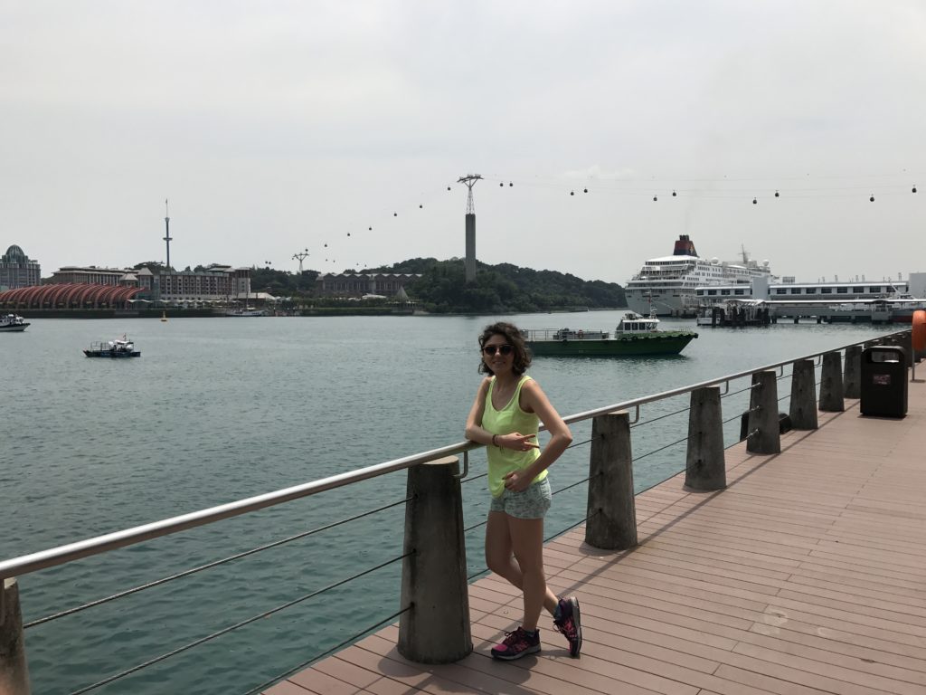 Denize karşı korkuluklara yaslanmış,gülümseyerek poz veren bir kız göüntüsü.