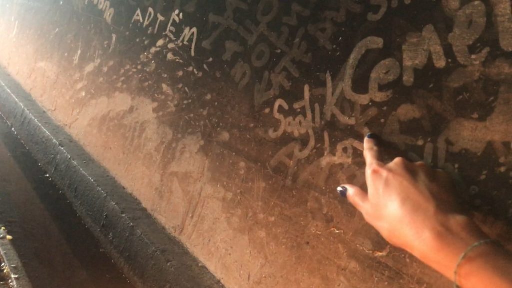 İsli bir duvar üzerine işaret parmağıyla dileklerini yazarken çekilmiş bir götüntü.