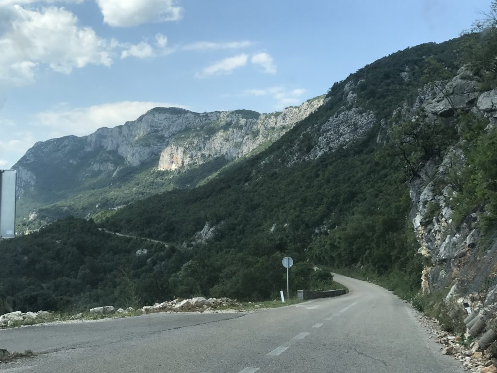 Dağların hemen yamacında hafif yeşil bir tabiat ile gidiş geliş dar bir yoldan çekilmiş görüntü.