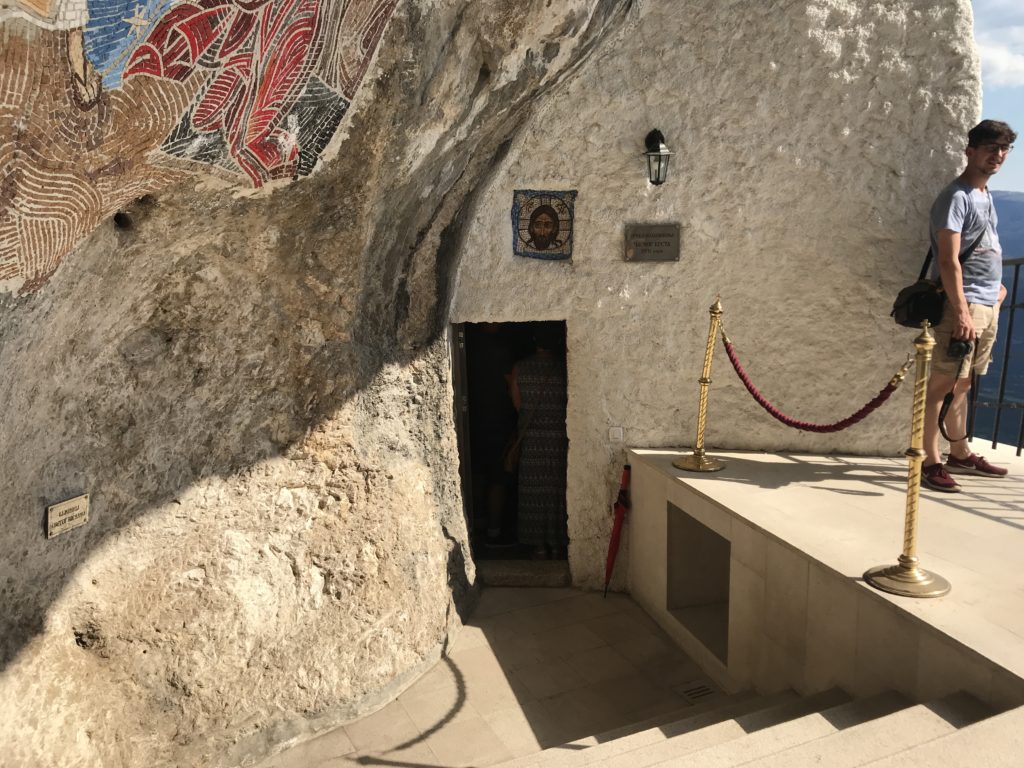 Küçük bir kapı girişi ve kapının hemen üzerinde yer alan Hz. İsa'nın fotoğrafı ile manastırdan bir görüntü.