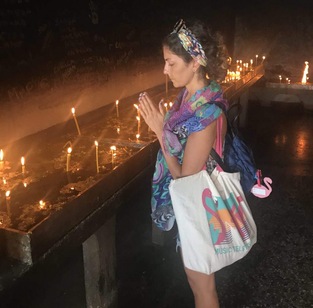 Dilek mumları önünde ellerini göğsünün önünde birleştirip dilek dilerken çekilmiş gezginstarın görüntüsü.