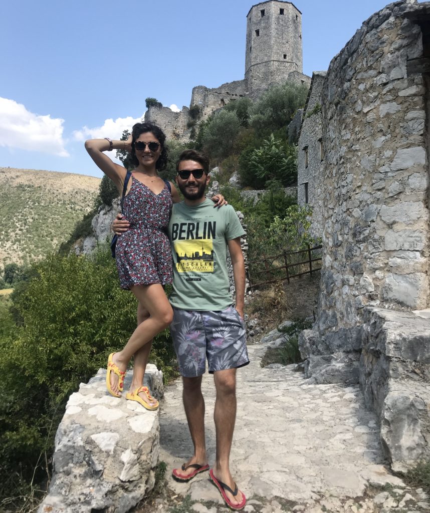 Duvarın üzerine çıkmış bir kız ve sevgilisine sarılıp arkasındaki tarihi kale ile poz verirken çekilmiş görüntüsü.
