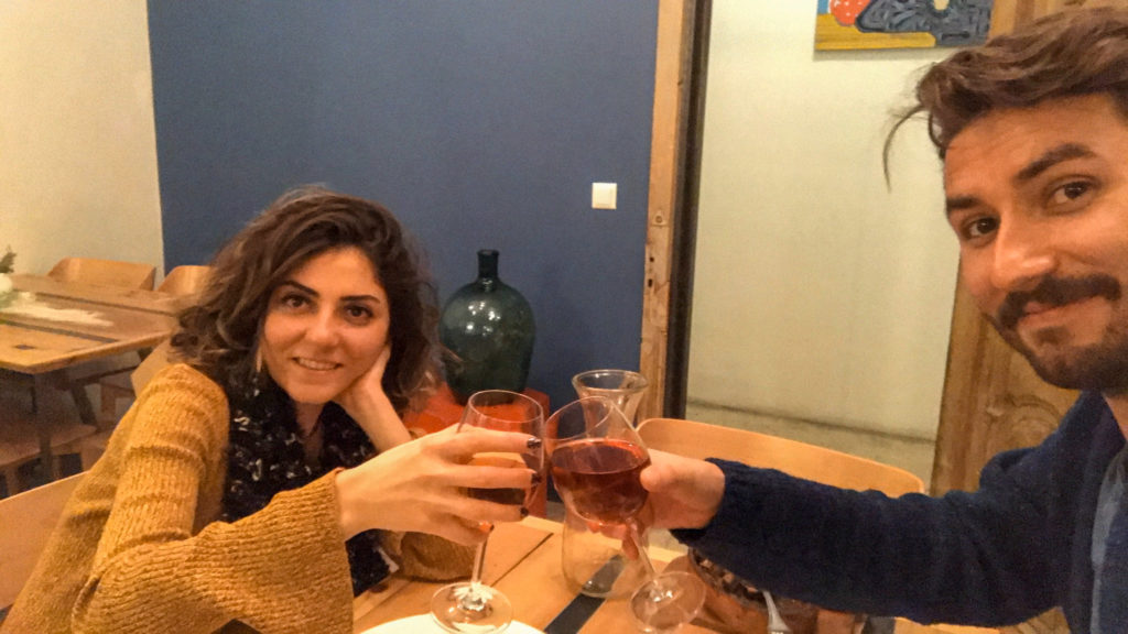 Yemek masasında çiftlerin kadeh tokuşturup gülümseyip poz verdiği Tiflis gezi rehberi yazısından bir görüntü.