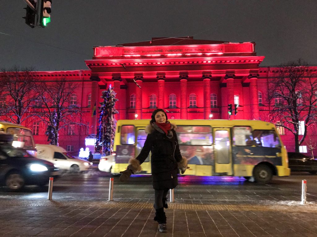 Akşam karanlığında kırmızı renkte üniversite binası önünde çekilmiş görüntü.