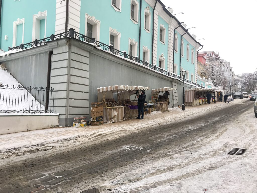 Karlı bir günde, kaldırım üzerinde açılan tezgahların yer aldığı görüntü.