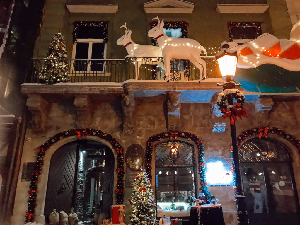 Binanın üzerinde yerleştirilen, ren geyikleri, kızak ve yeni yıl süsleriyle tasarlanmış noel pazarından görüntü.